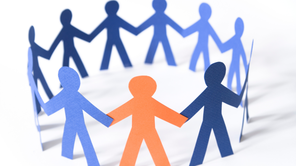 Paper people figures holding hands in a circle