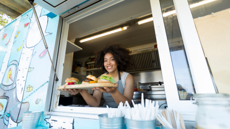 Woman holding burgers out of food truck window