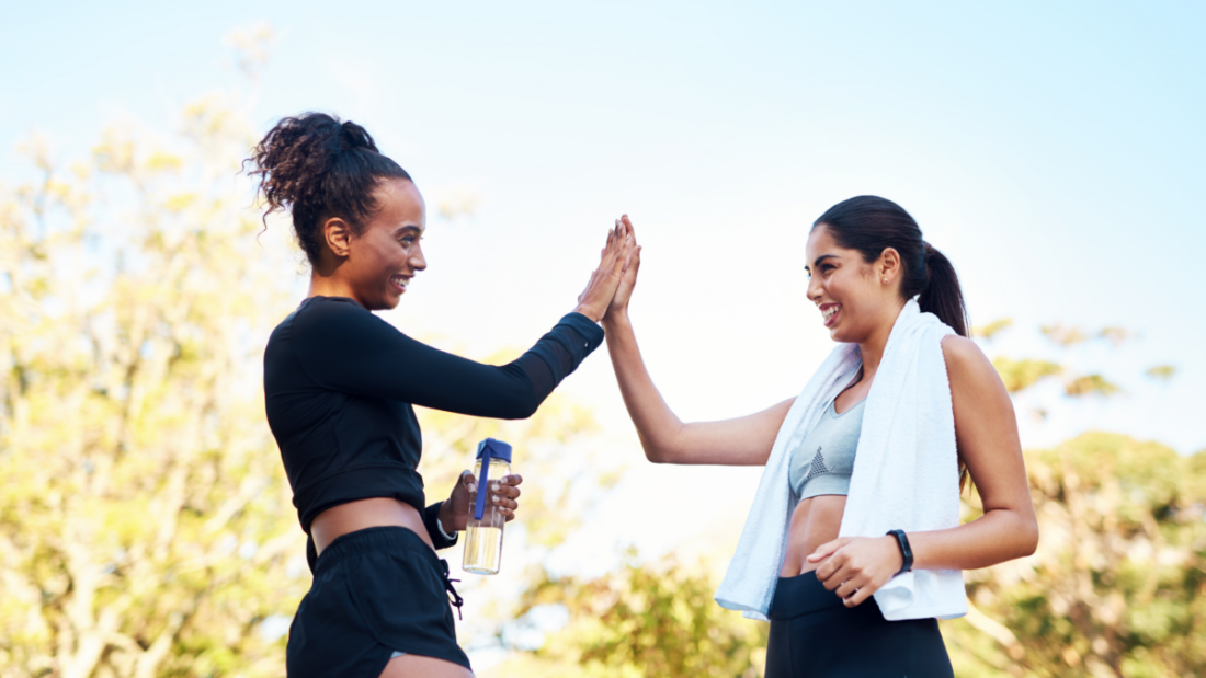 two woman high fiving after a work out