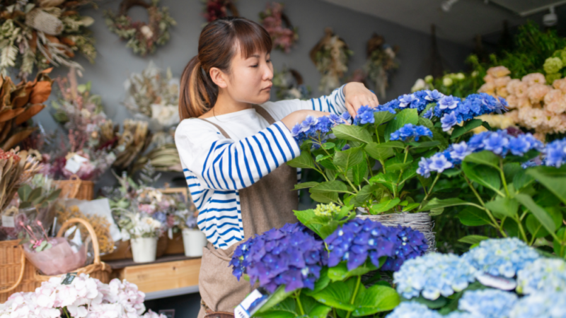 florist cutting flowers in her shop